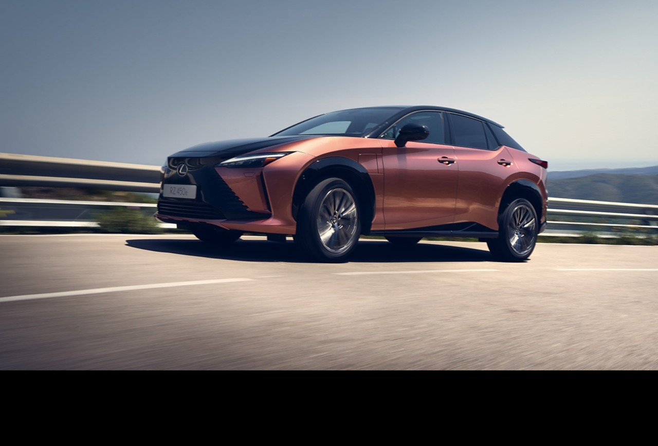 Side view of the Lexus RZ driving in a rural environment 