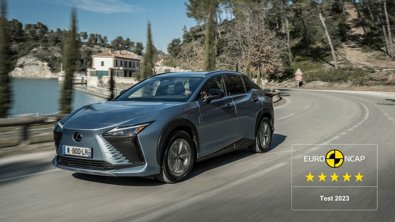 Lexus RZ driving along a waterfront