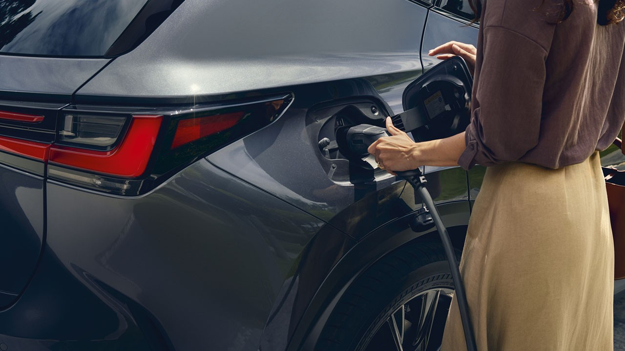 A woman plugging in a Lexus NX 