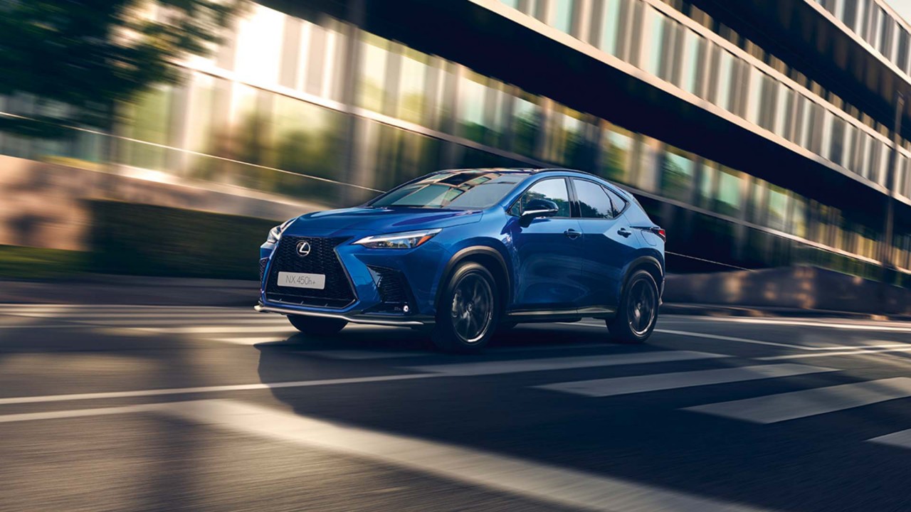 Lexus NX 450h+ driving in a city location 